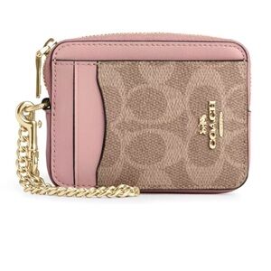 Coach zip card case in pink with gold hardware.